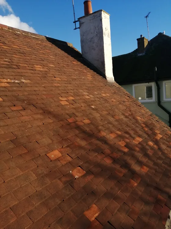 The same hipped roof with the moss removed and the clay tiles back to terracotta