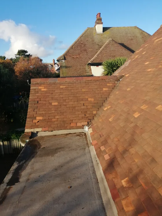 The same slope and flat roof after cleaning, the tiles returned to red clay